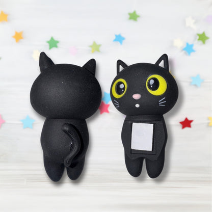 Two black cat-shaped clips with one having a small square attached on a light background with colorful stars.
