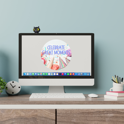 Computer monitor on a desk with a 'Celebrate Great Moments' screen, surrounded by office supplies. Black cat figurine with yellow eyes on a computer monitor